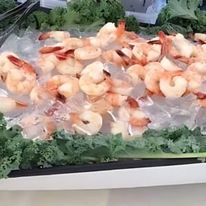 A tray of shrimp and lettuce on top of the table.